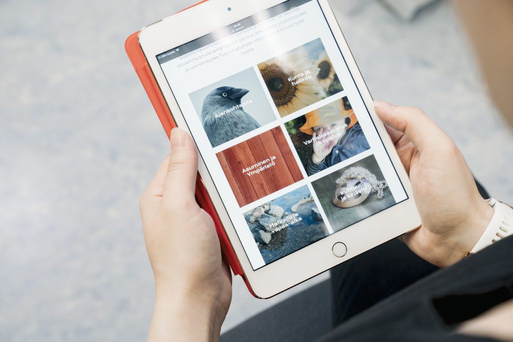 Henkilö selaa tabletilla verkkosivuja. 