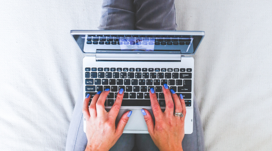 Nainen työskentelee sohvalla.